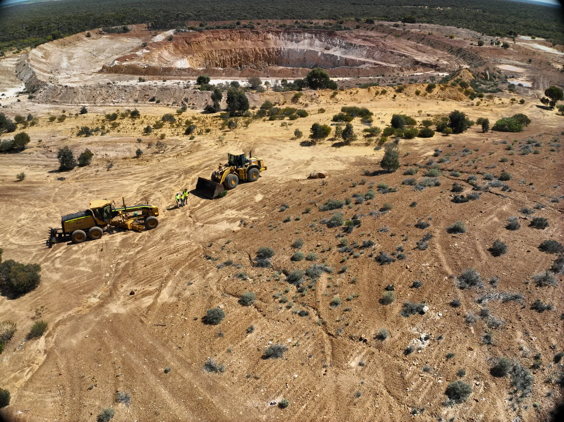 Personnel, a loader and a grader beside historical workings at Holleton